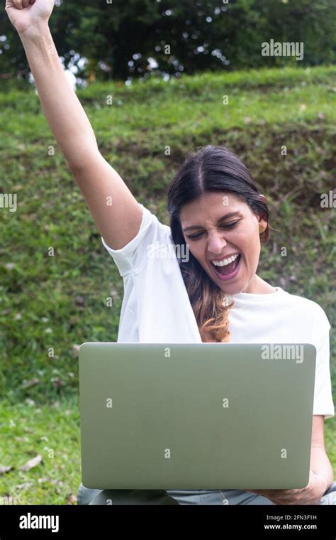 Happy Latin Female Celebrating While Receiving Amazing News On Laptop