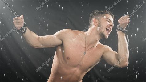 Strong Man In Chains Posing Under The Rain Aqua Studio Stock Photo Mkolesnikov