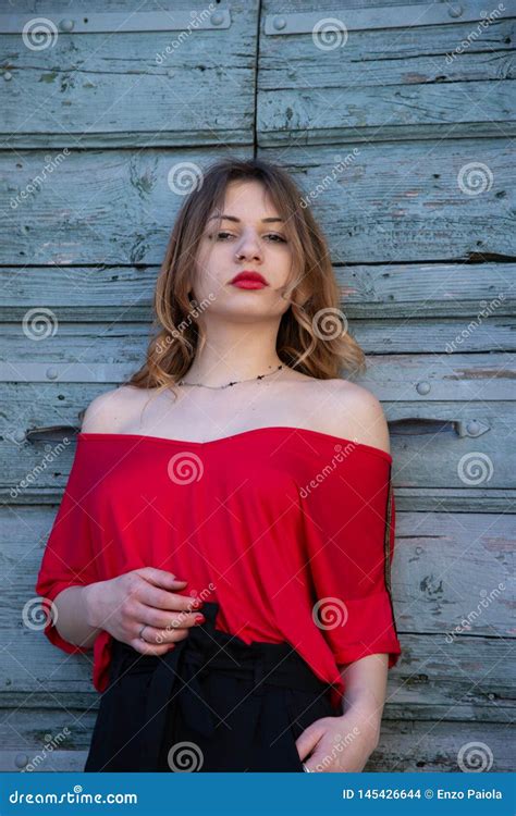 portrait d une fille blonde très sensuelle il utilise une chemise rouge qui dessine son corps