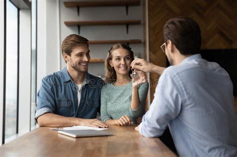 Male Realtor Give Keys To Home To Excited Couple Stock Image Image Of Achievement Married