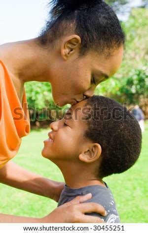 Happy African American Mother Kissing Son Stock Photo