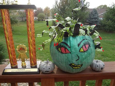 A Pumpkin Decorated With Plants And Decorations On A Porch