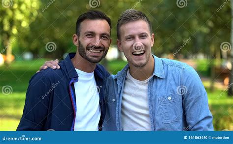 Best Male Friends Hugging Smiling On Camera Outdoors Supporting