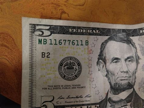 The mirrored serial number on this $5 bill, including the ...
