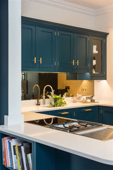 Dark Teal Kitchen Design With Gold Accents And Mirrored Backsplash