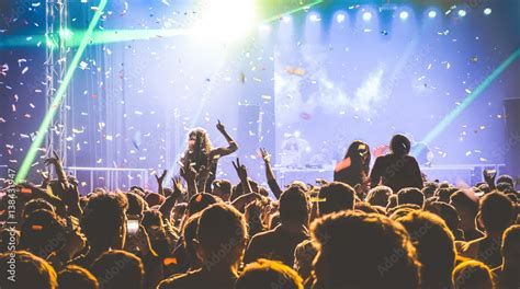 Young People Dancing At Night Club Hands Up And Multicolored Confetti