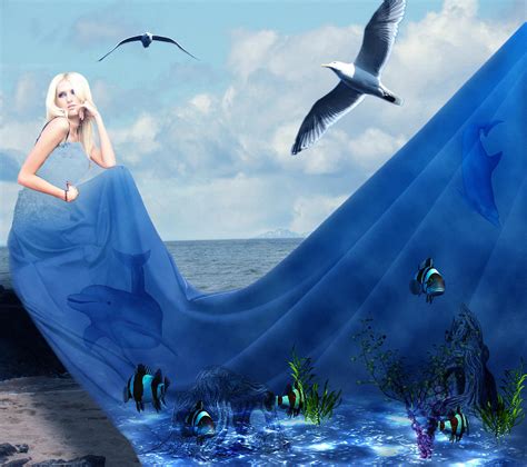Фото Девушка блондинка сидит на берегу моря в длинном голубом платье на котором изображен