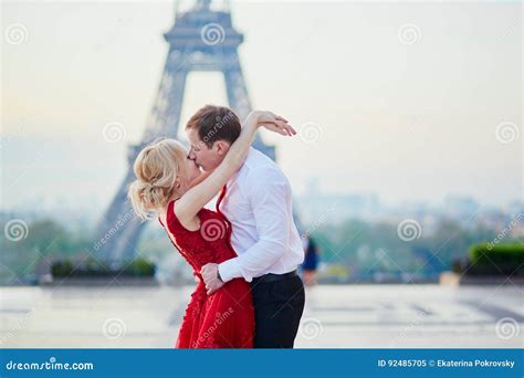 Couple Kissing In Front Of The Eiffel Tower In Paris France Stock