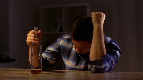 alcoholism, alcohol addiction and people concept - male alcoholic drinking whiskey from bottle ...