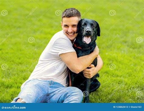 Guy Hugging With His Dog Labrador Playing In The Park Stock Image