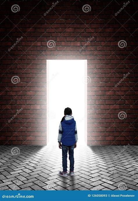 Little Girl Is Standing In Front Of A Doorway In A Wall Behind Which A