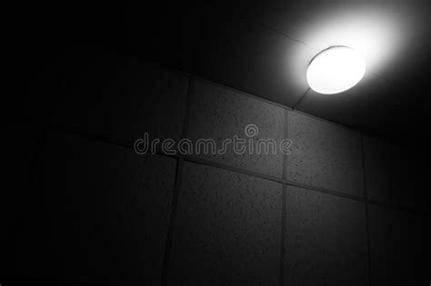 Bright Lamp On The Ceiling In Dark Room Black And White Minimalistic
