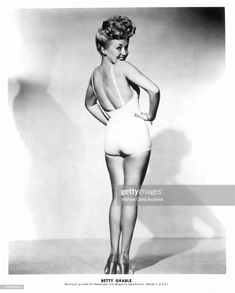 Betty Grable In A Bathing Suit And High Heel Looking Over Her News