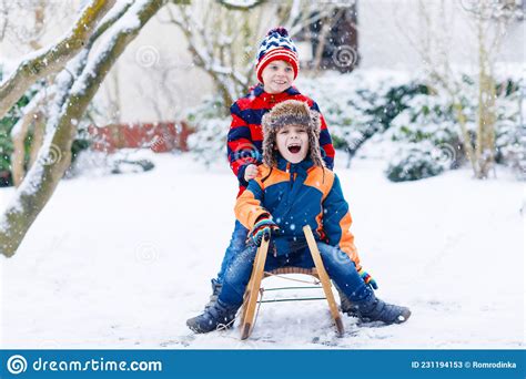 Two Kid Boys Having Fun Sleigh Ride During Snowfall Children Sledding