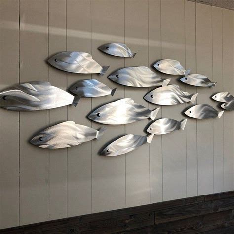A Group Of Metal Fish Mounted To The Side Of A Wall