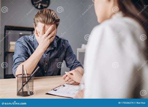 Young Female Psychologist Comforting Her Male Patient Stock Photo