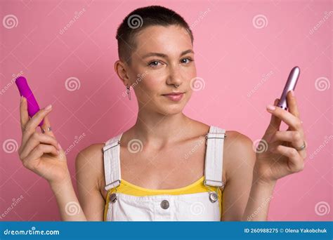 Short Haired Girl In White Overalls Posing With Two Vibrator For