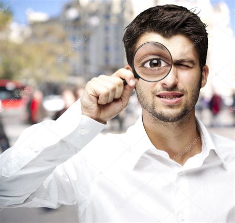 Portrait Of Young Man Looking Through A Magnifying Glass Stock Photo By