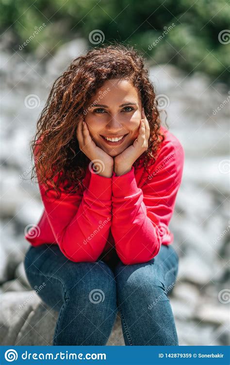Cheerful Young Woman With Curly Hair Posing While Sitting Outside Stock Image Image Of Curly