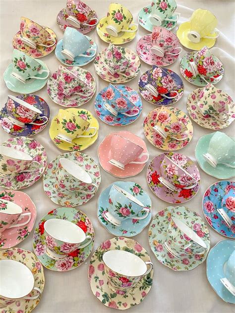 A Bunch Of Tea Cups And Saucers On A Table With Plates In The Shape Of