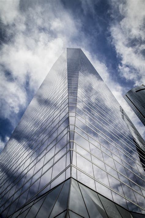 Skyscraper With Glass Facade And Clouds Reflected In Windows Stock
