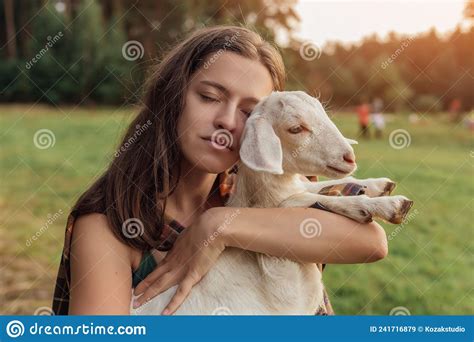 Beautiful Woman Farmer With Small Goat In Countryside Have Friendship In Nature Stock Image