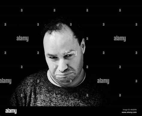 Portrait Of Man Making Face Against Black Background Stock Photo Alamy