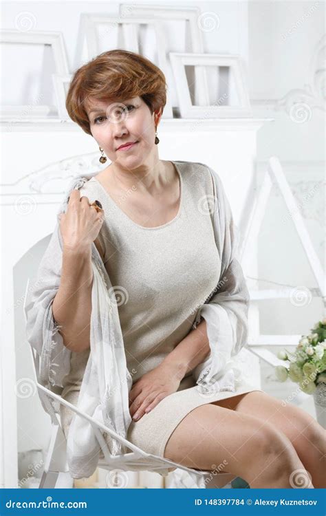 A Middle Aged Woman On A Chair In The Living Room Stock Photo Image