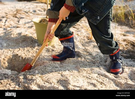 Boy Digging Hole In Sand Stock Photo Alamy