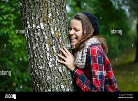 Teenage Girl Leaning On Tree In Forest Stock Photo Alamy