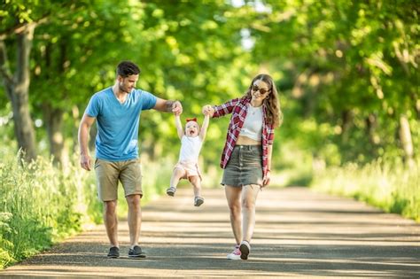 Familia Feliz Padre Y Madre Disfrutando De Un Paseo Por El Parque Con