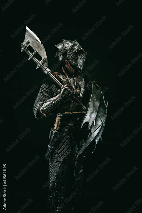 Medieval Fighter In Armor Carrying A Shield And An Ax On His Shoulder