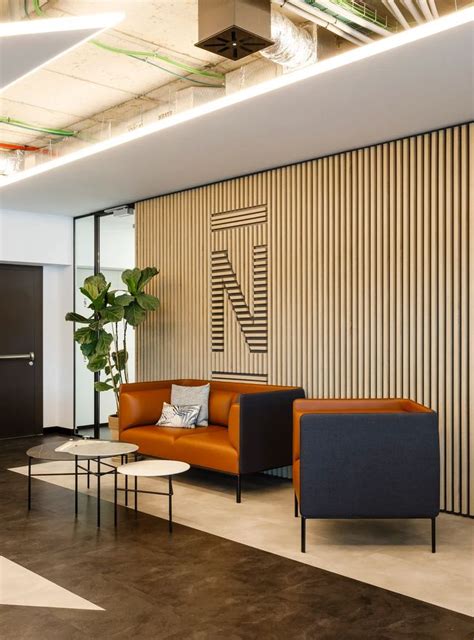 An Office Lobby With Two Couches And A Coffee Table In Front Of The Wall