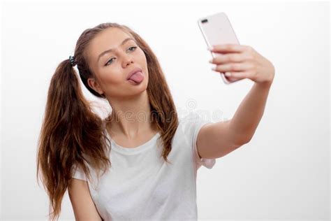 Śmieszna wspaniała dziewczyna sshowing jej jęzor podczas gdy brać selfie zdjęcie stock obraz