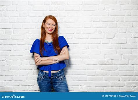 Facial Expressions Of Young Redhead Woman On Brick Wall Stock Photo