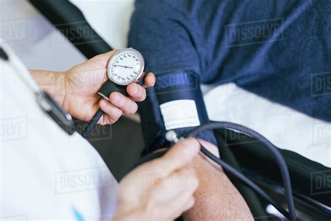 Close Up Of Doctor Checking Patient Blood Pressure At Hospital Stock