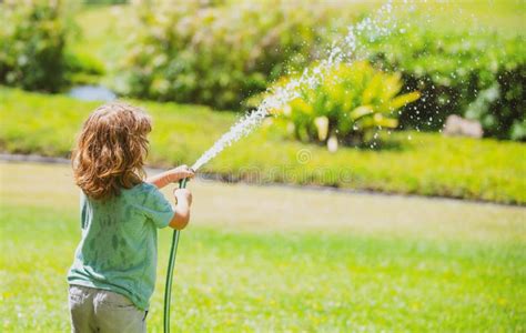 Kids Play With Water Garden Hose In Yard Outdoor Children Summer Fun