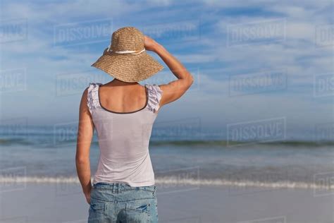 Woman Wearing Straw Hat On Beach Stock Photo Dissolve