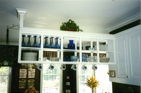The Shelves In The Kitchen Are Filled With Dishes And Vases On Top Of Them