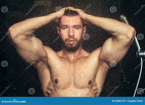 fitness male taking a shower and holding hands in head close up shower and bath details stock