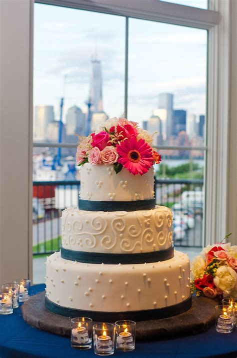 Three Tier Patterned Wedding Cake With Navy Stripes And Coral Flowers