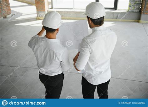 Male Architect Giving Instructions To His Foreman At Construction Site