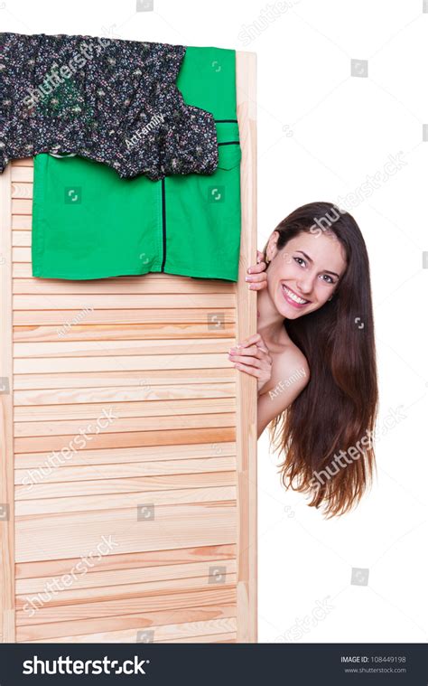Smiley Young Woman Changing Her Clothes Behind Wood Screen Stock Photo
