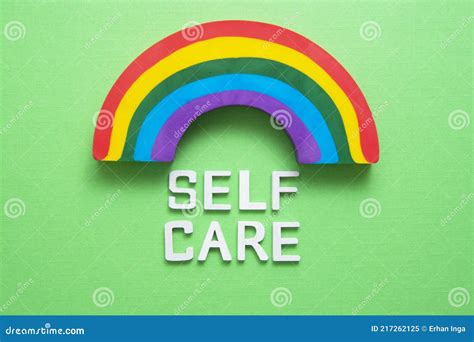 Self Care Word Abstract Quote On Wooden Blocks With Rainbow Over Green