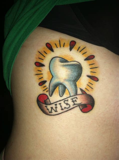 A Woman With A Tattoo On Her Stomach Has A Tooth And Ribbon In Front Of