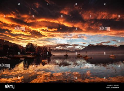 Dawn At Lake Thun In Switzerland With Red Clouds Reflecting On The