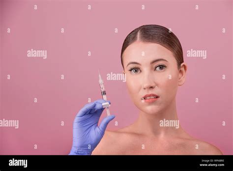 Women With Perfect Skin Posing Holds A Syringe In Their Hand Conceptual Image Of Plastic