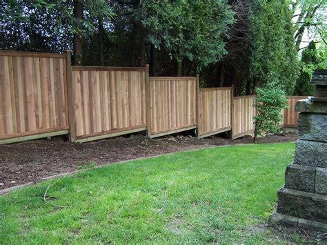Building A Fence On Sloped Ground Sloped Yard Fence Landscaping