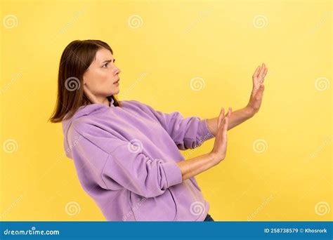 side view of frightened shocked woman raising hands in fear looking horrified and panicking