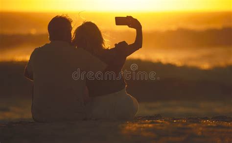 Back Of A Senior Couple Taking Selfies On The Beach Mature Woman Using